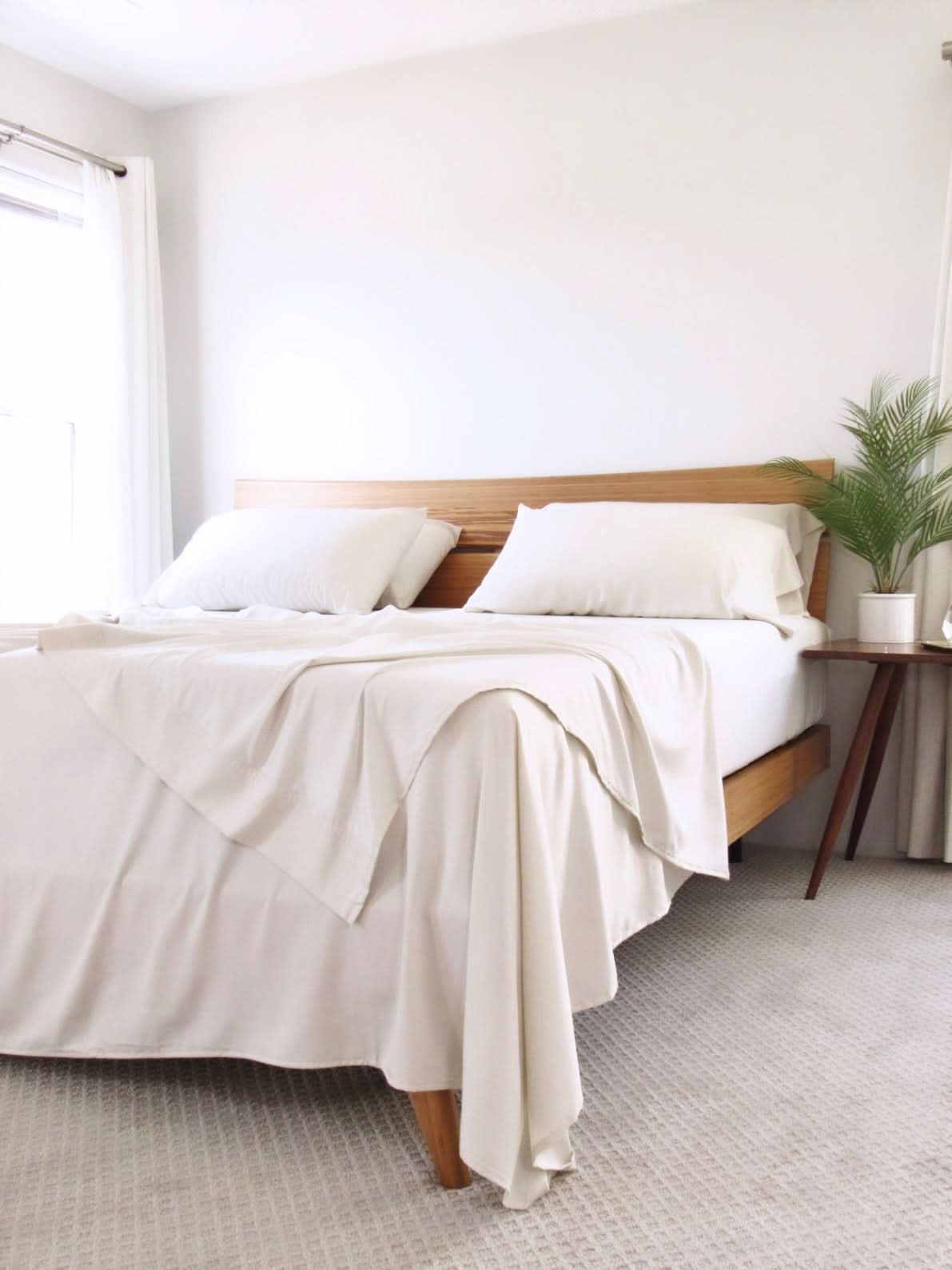 White Copper Infused Bamboo Pillowcase Set on a bed with wooden headboard.